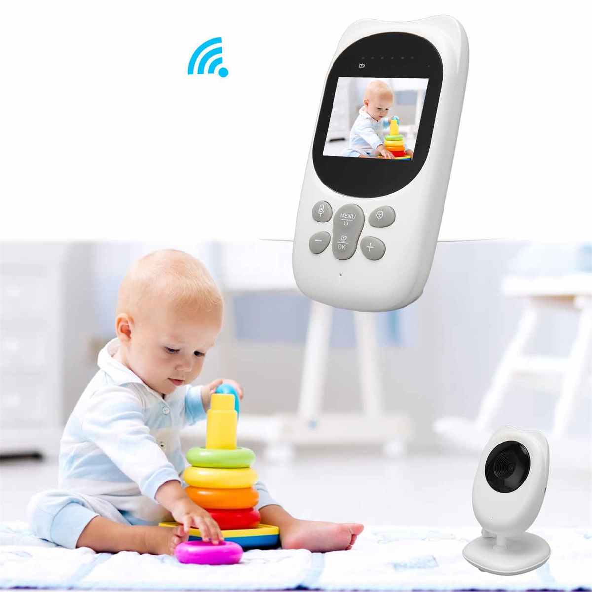 Ein Baby beobachtet einen Monitor, der ein Baby beim Spielen mit einem Spielzeug zeigt. Eine Kamera steht darunter auf dem Tisch.