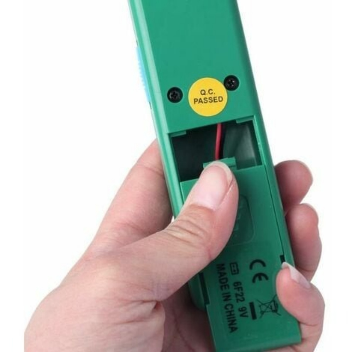 Grünes Gerät mit geöffnetem Batteriefach. Eine Hand hält das Gerät. Nahaufnahme.