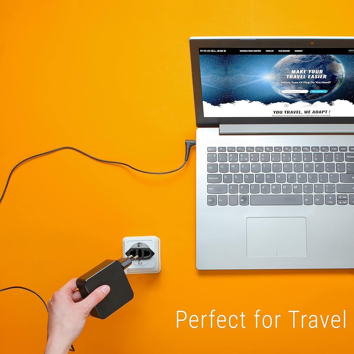 Ein Laptop mit einer Website auf dem Bildschirm. Der Laptop steht auf einer gelben Oberfläche. Eine Hand steckt ein schwarzes Ladegerät ein.