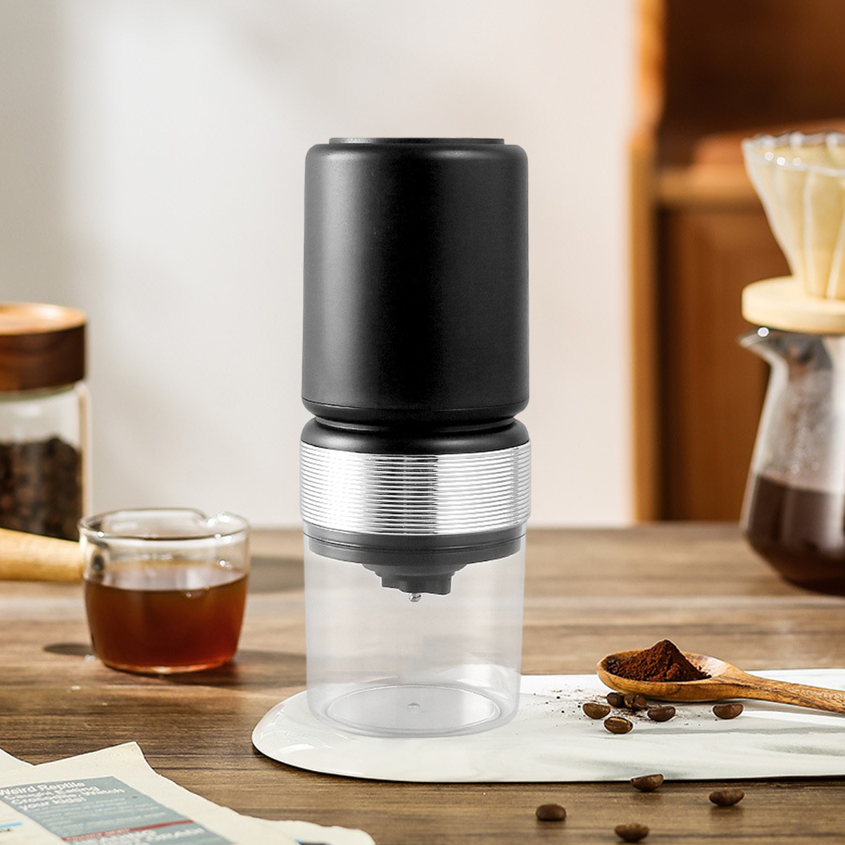 Schwarze und transparente Kaffeemaschine. Schwarze Oberseite, transparenter Mittelteil, auf Holztisch.