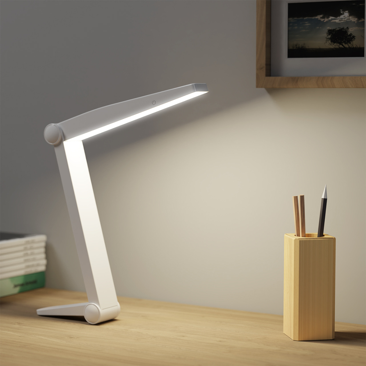 Eine weiße Schreibtischlampe mit Licht, neben einem Stifthalter.