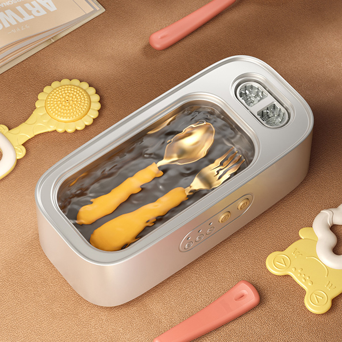 Silberner Behälter mit goldenem Besteck. Umgeben von Kinderspielzeug auf hellbrauner Oberfläche.