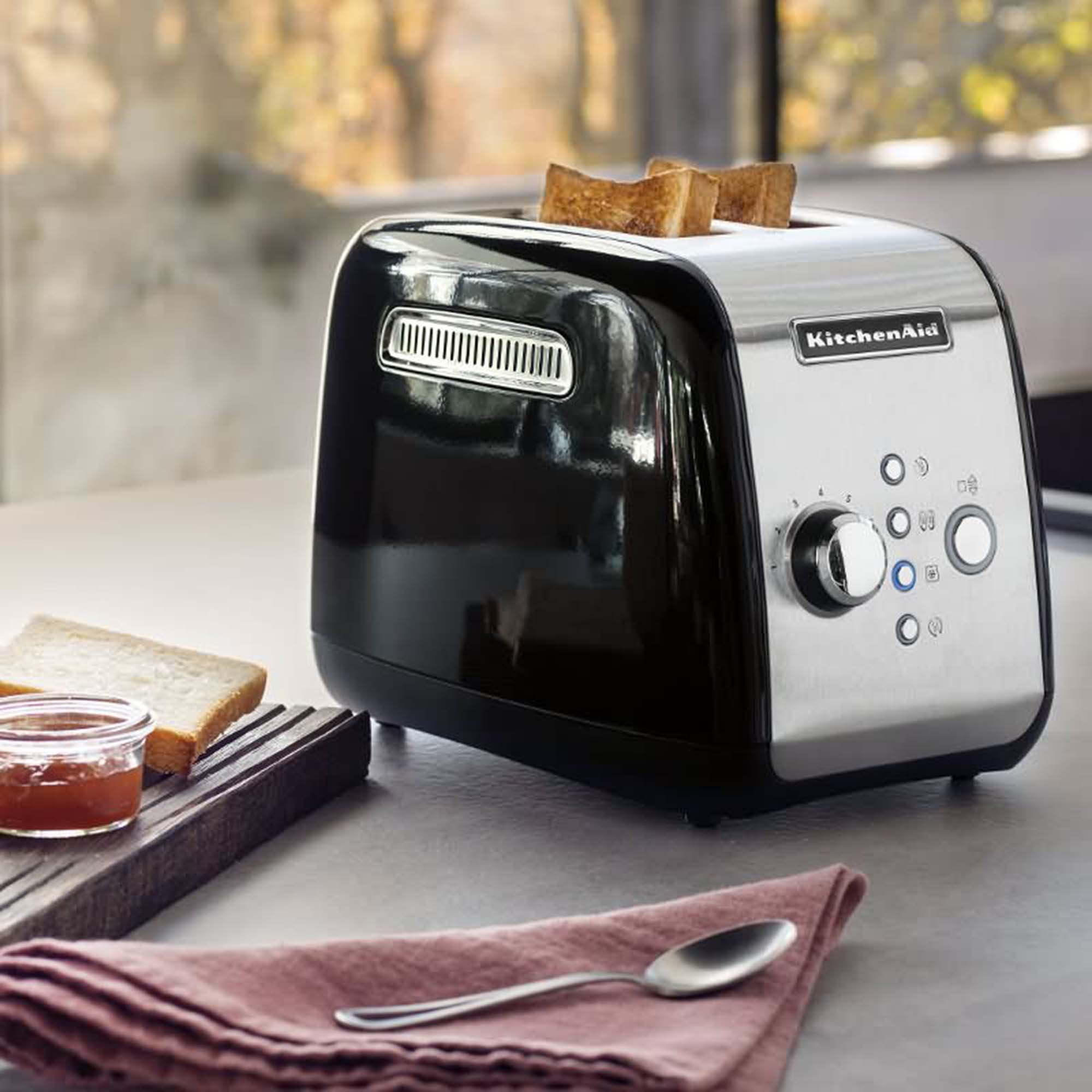 Black and silver toaster with toast and jam.