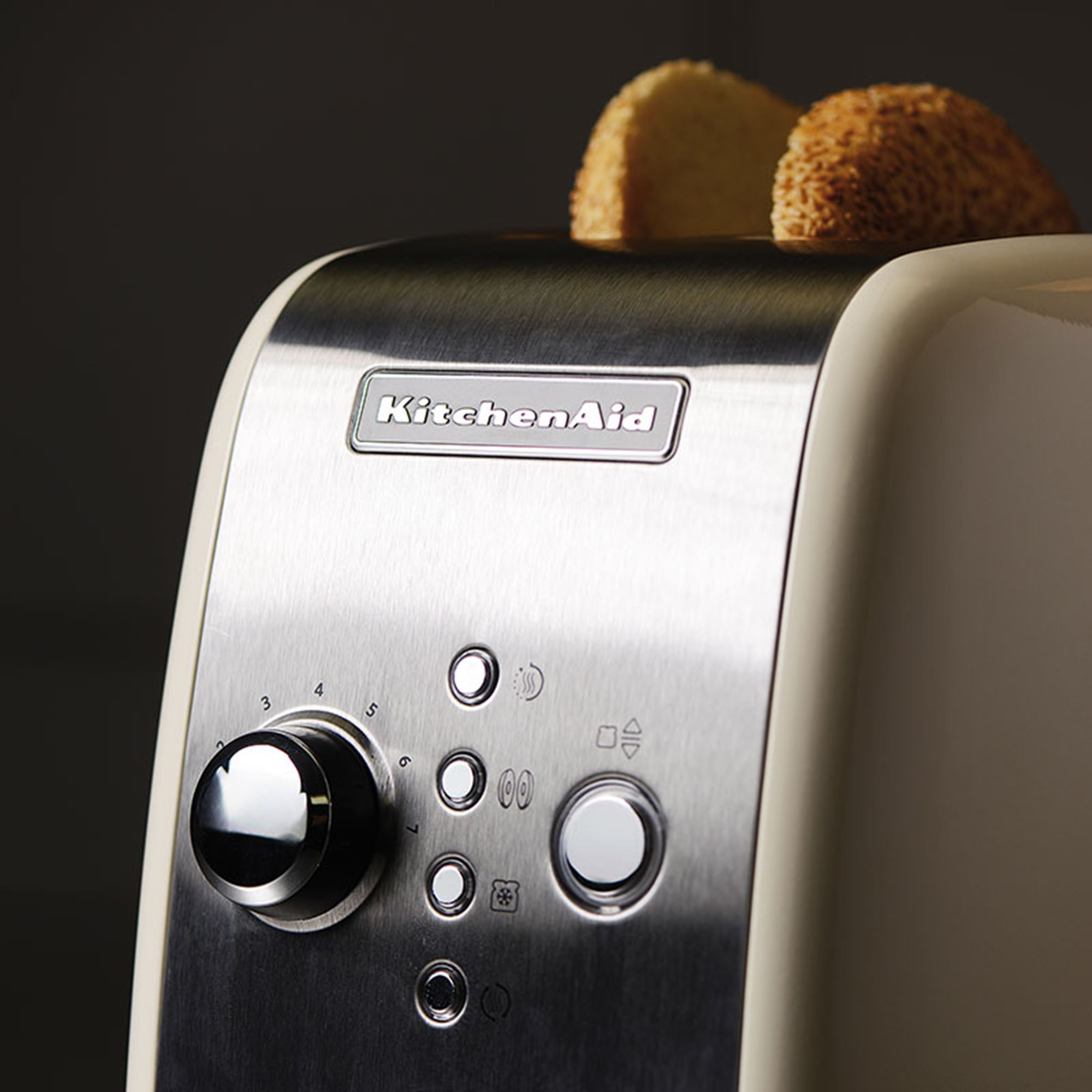 Cream KitchenAid toaster. Toasted bread slices are popping up.