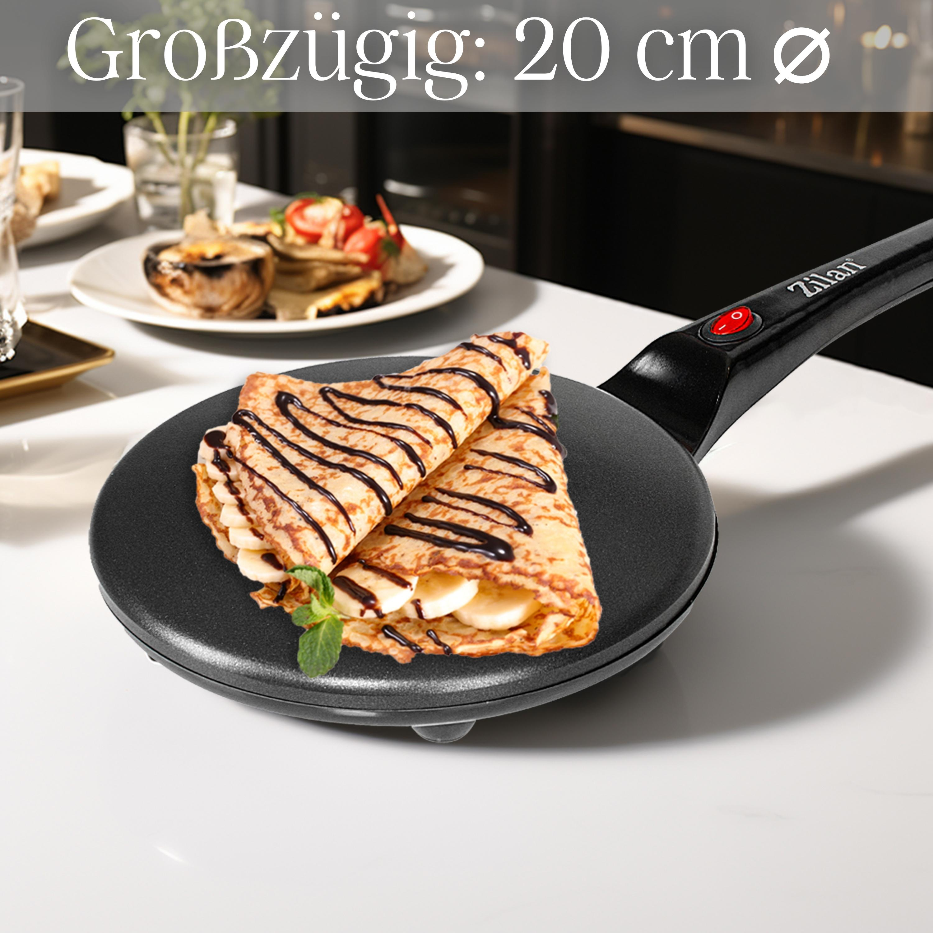 Eine schwarze Crêpe-Pfanne mit Crêpes und Schokoladensauce, garniert mit Minze. Text sagt 20 cm Durchmesser.