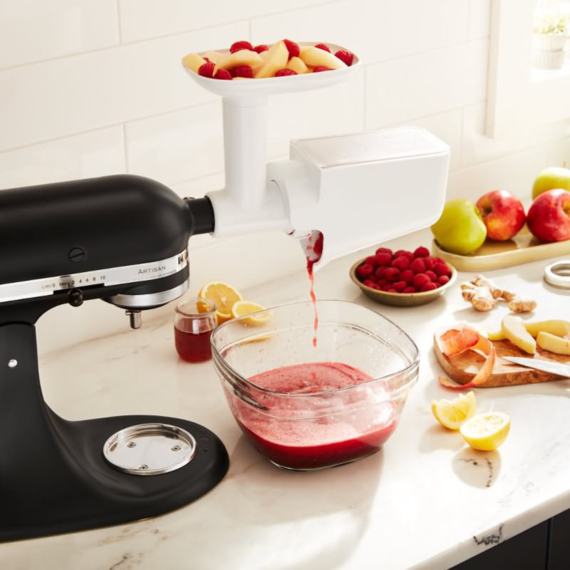 Frullatore KitchenAid nero con spremiagrumi, che produce succo rosso in una ciotola di vetro.