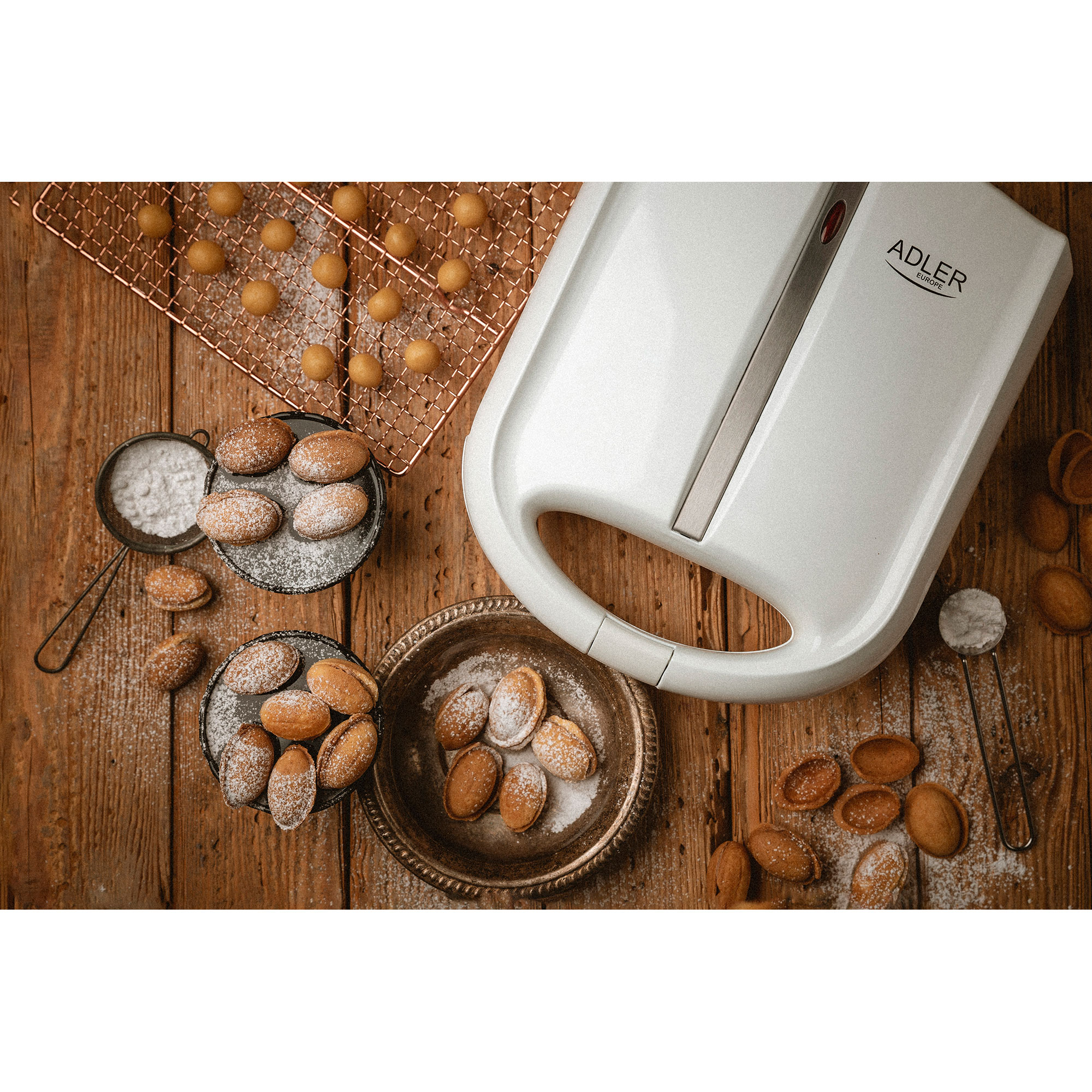 Ciasteczka w kształcie orzecha włoskiego, posypane cukrem pudrem, na drewnie.