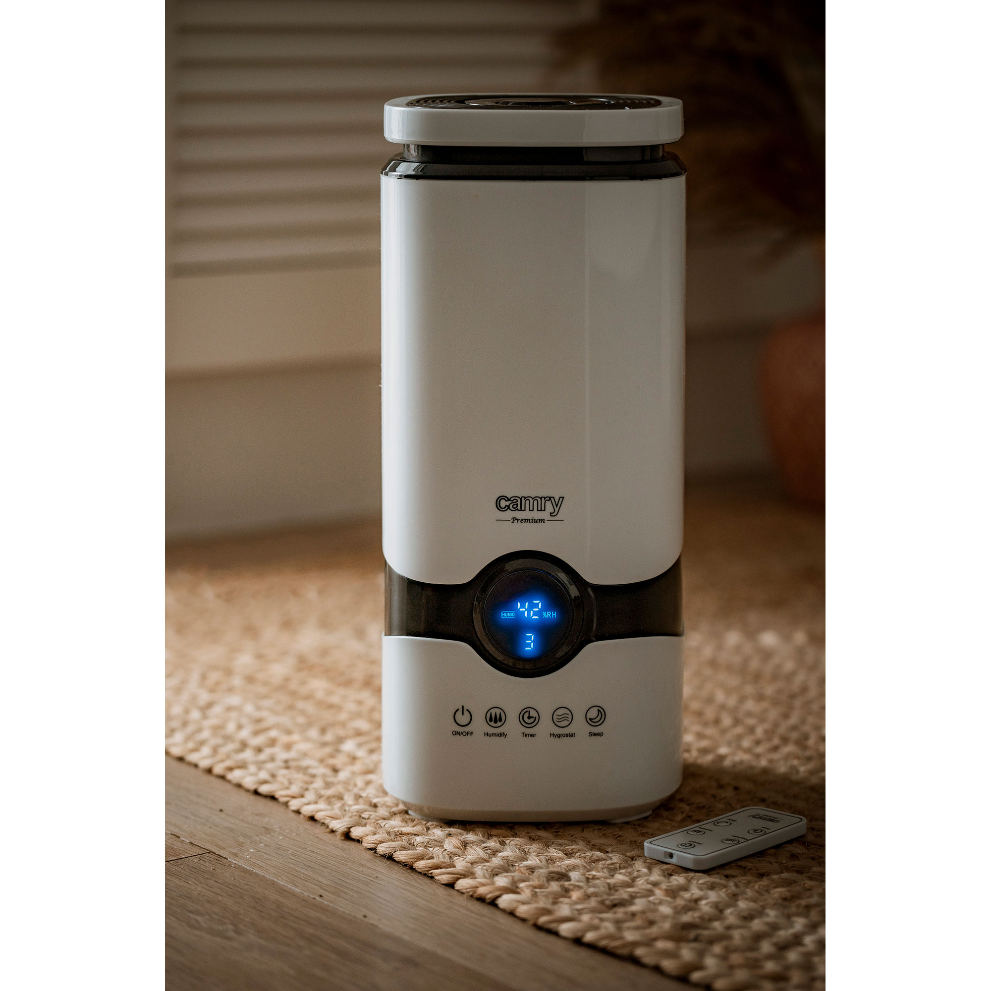 Biały nawilżacz z wyświetlaczem z numerami, na plecionej macie, z pilotem.