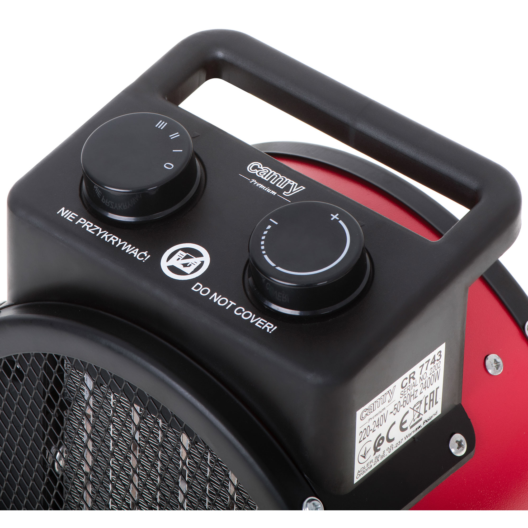 Zbliżenie czarno-czerwonego grzejnika elektrycznego z pokrętłami sterowania.