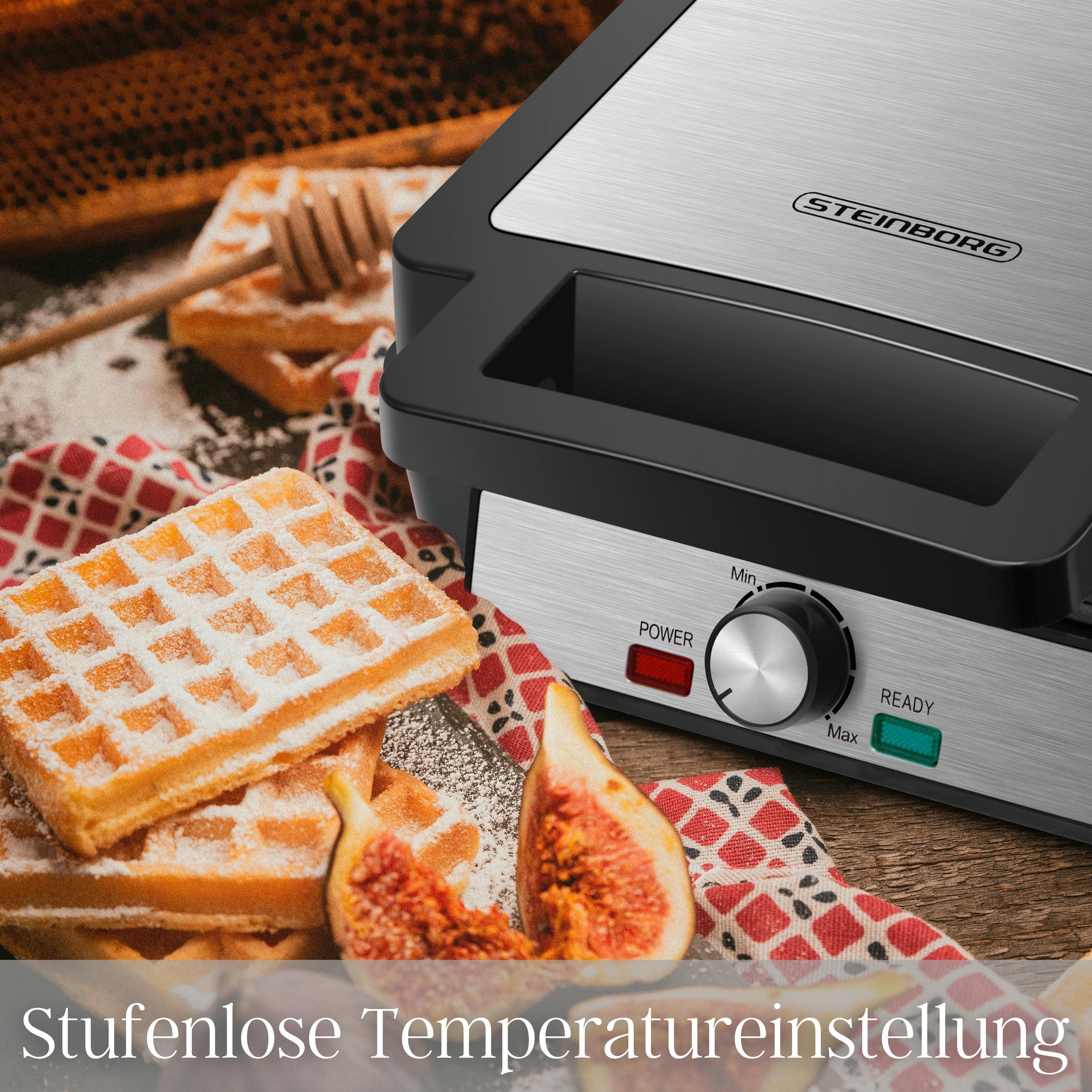 Ein Waffeleisen mit Waffeln, Feigen und einem Honiglöffel wird gezeigt. Die Maschine ist schwarz und silber mit einem Bedienknopf.