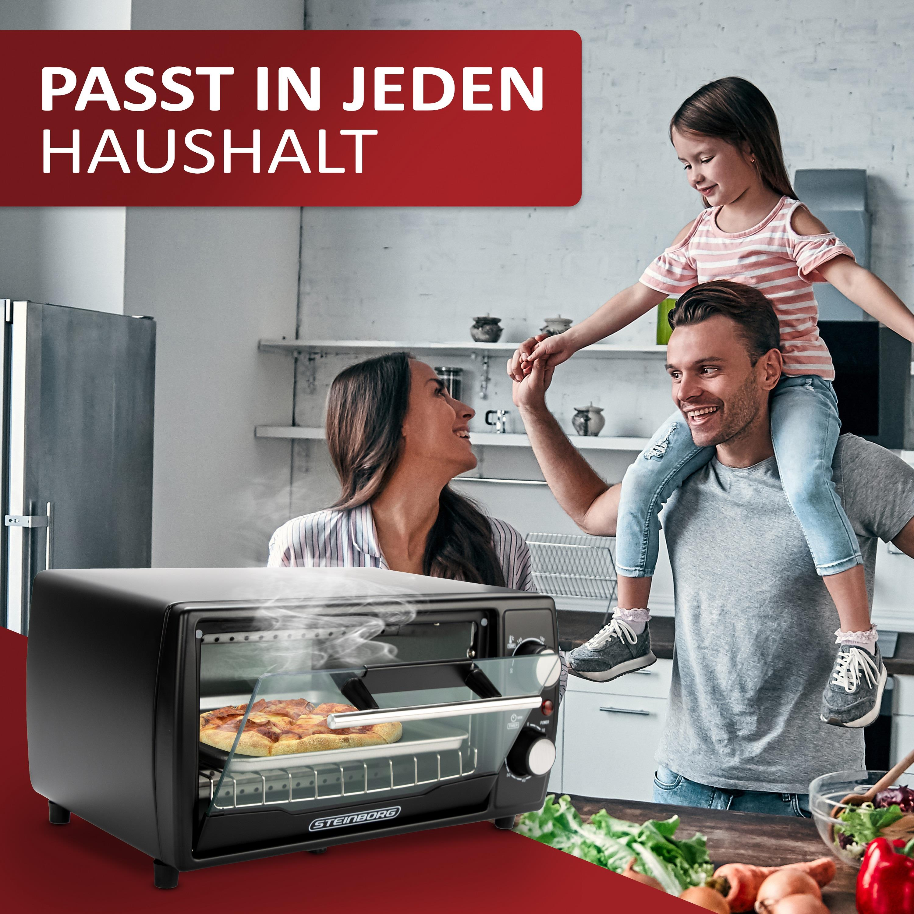 Eine Familie steht in der Nähe des Ofens, der Pizza enthält. Eine Frau, ein Mann hält ein Kind.
