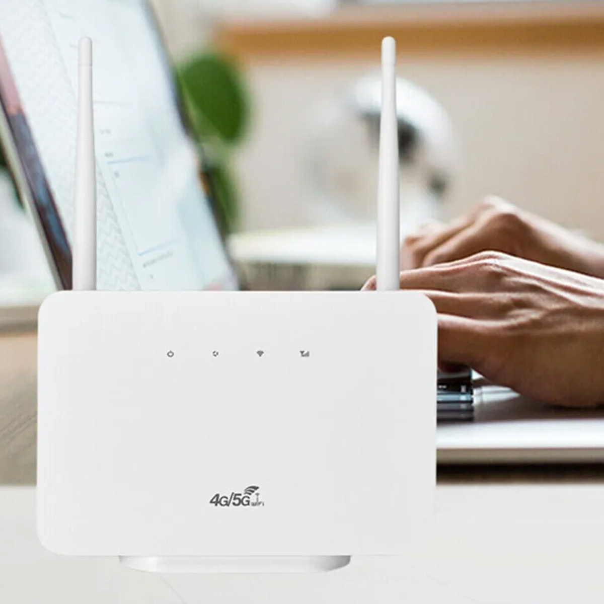 Weißer Router mit zwei Antennen und Kontrollleuchten. Hände einer Person und ein Laptop im Hintergrund.