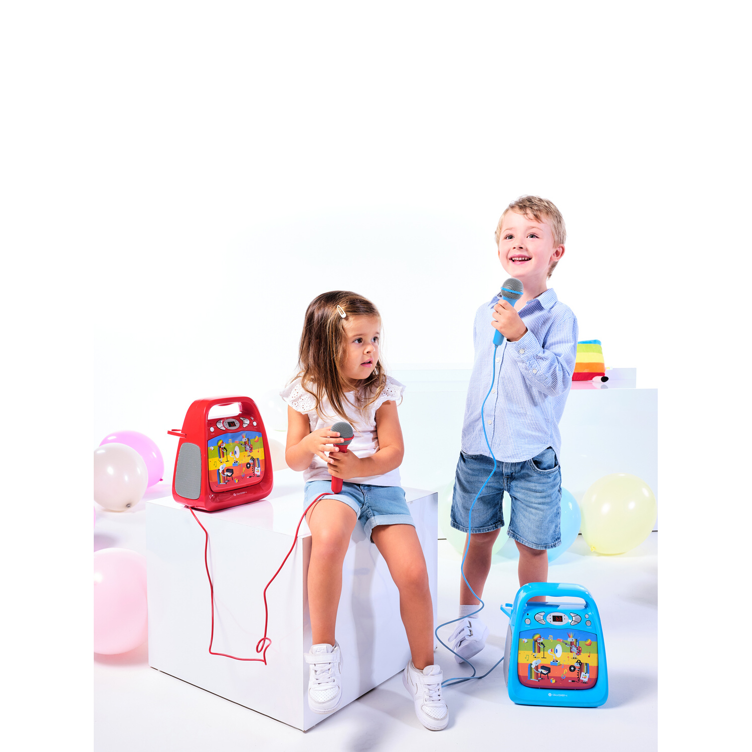 Zwei Kinder mit Mikrofonen und Karokespielzeugen, umgeben von bunten Ballons.