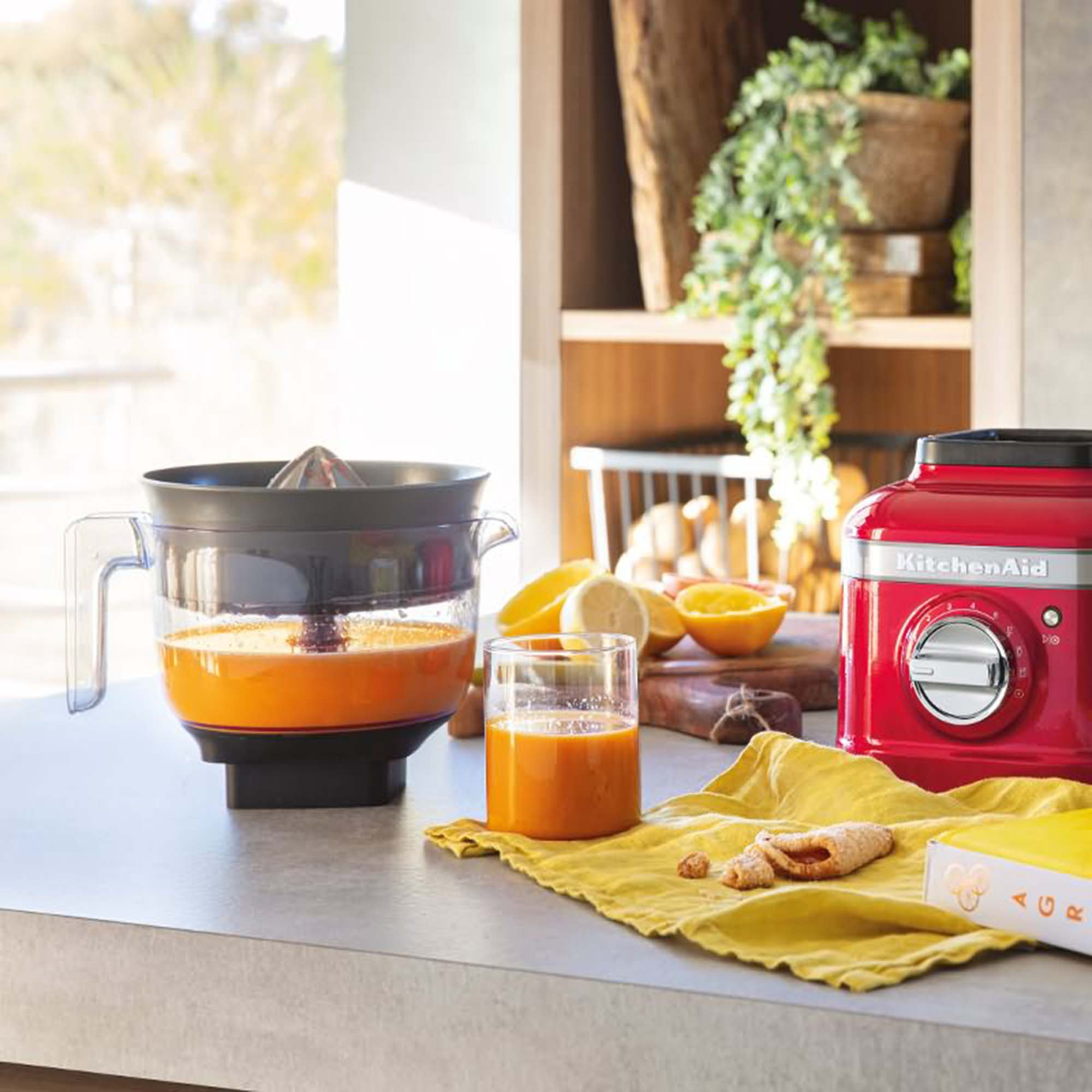 Kırmızı bir KitchenAid mikseri ve portakal suyu ve meyvelerle sıkacağı.