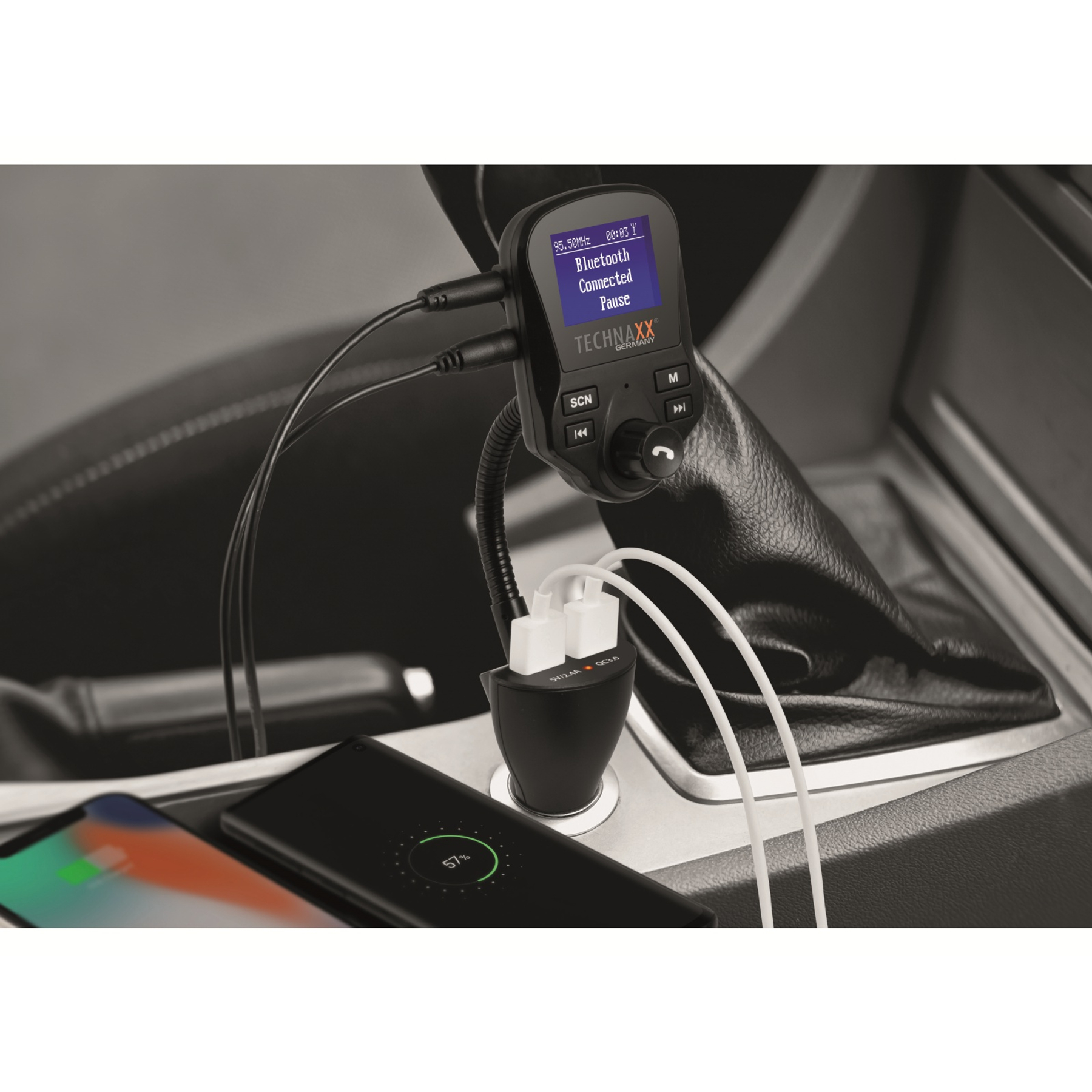 Ein Autointerieur mit einem schwarzen Ladegerät und einem ladenden Telefon. Das Ladegerät hat USB-Anschlüsse und ein Display.