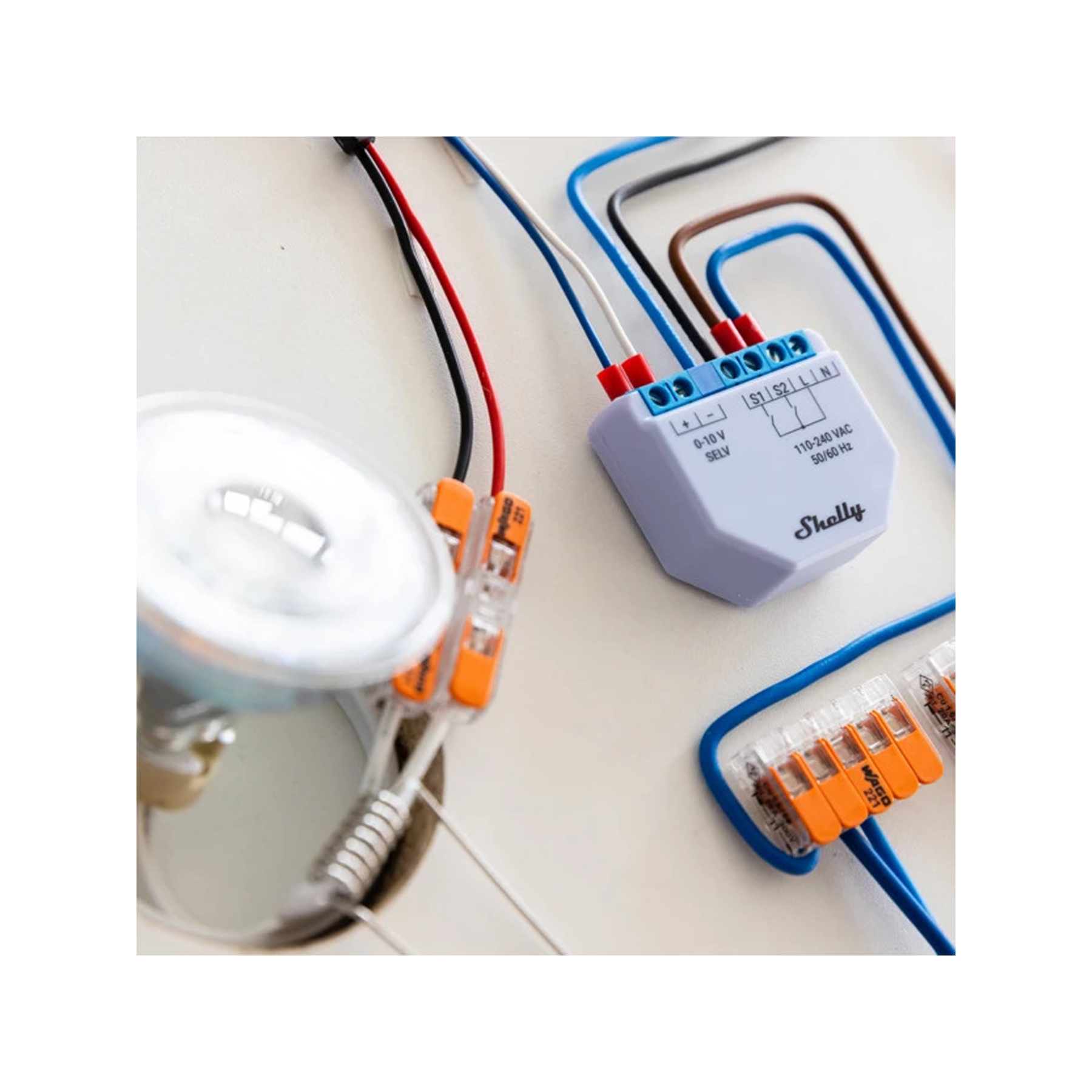 Cableado eléctrico con conectores naranjas y un dispositivo Shelly, conectado a un foco.