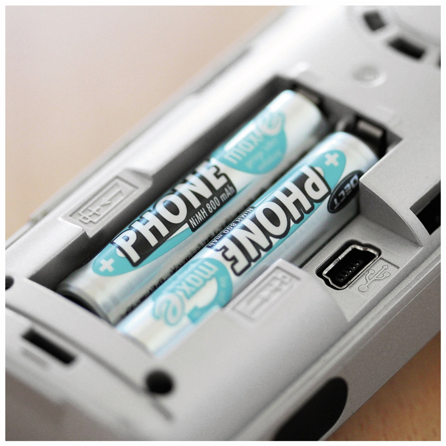 Dwie cylindryczne baterie w urządzeniu, z tekstem i portem USB.