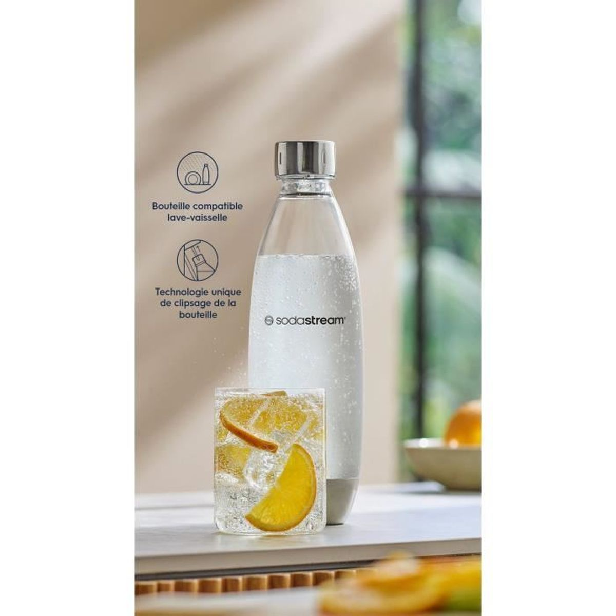 Una bottiglia Sodastream e un bicchiere con fette d'arancia e ghiaccio. Una bottiglia è a sinistra.