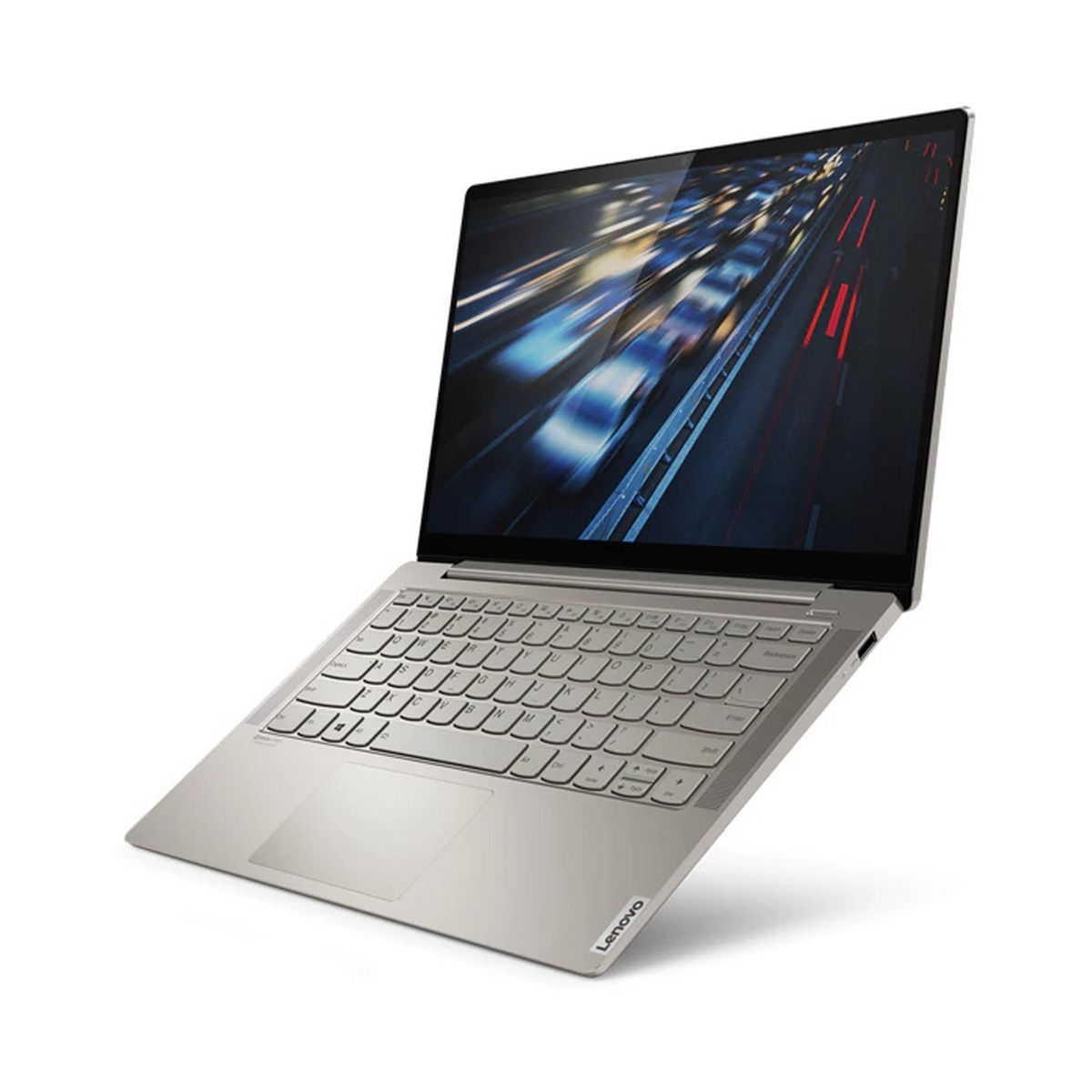 Un laptop argentato aperto mostra un display con uno sfondo sfocato di una strada.