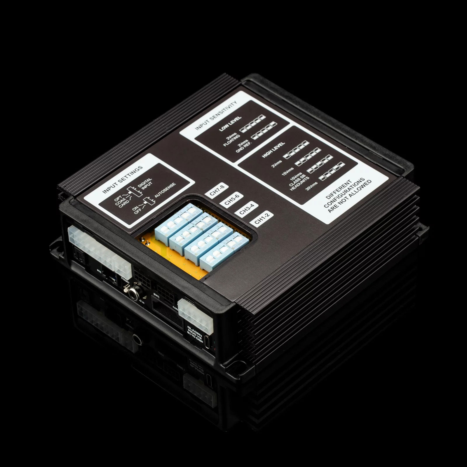 Ein schwarzes elektronisches Gerät mit verschiedenen Anschlüssen und Etiketten auf schwarzem Untergrund.
