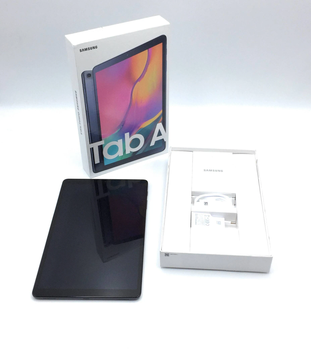 Tablet e accessori in una scatola bianca, accanto alla scatola.