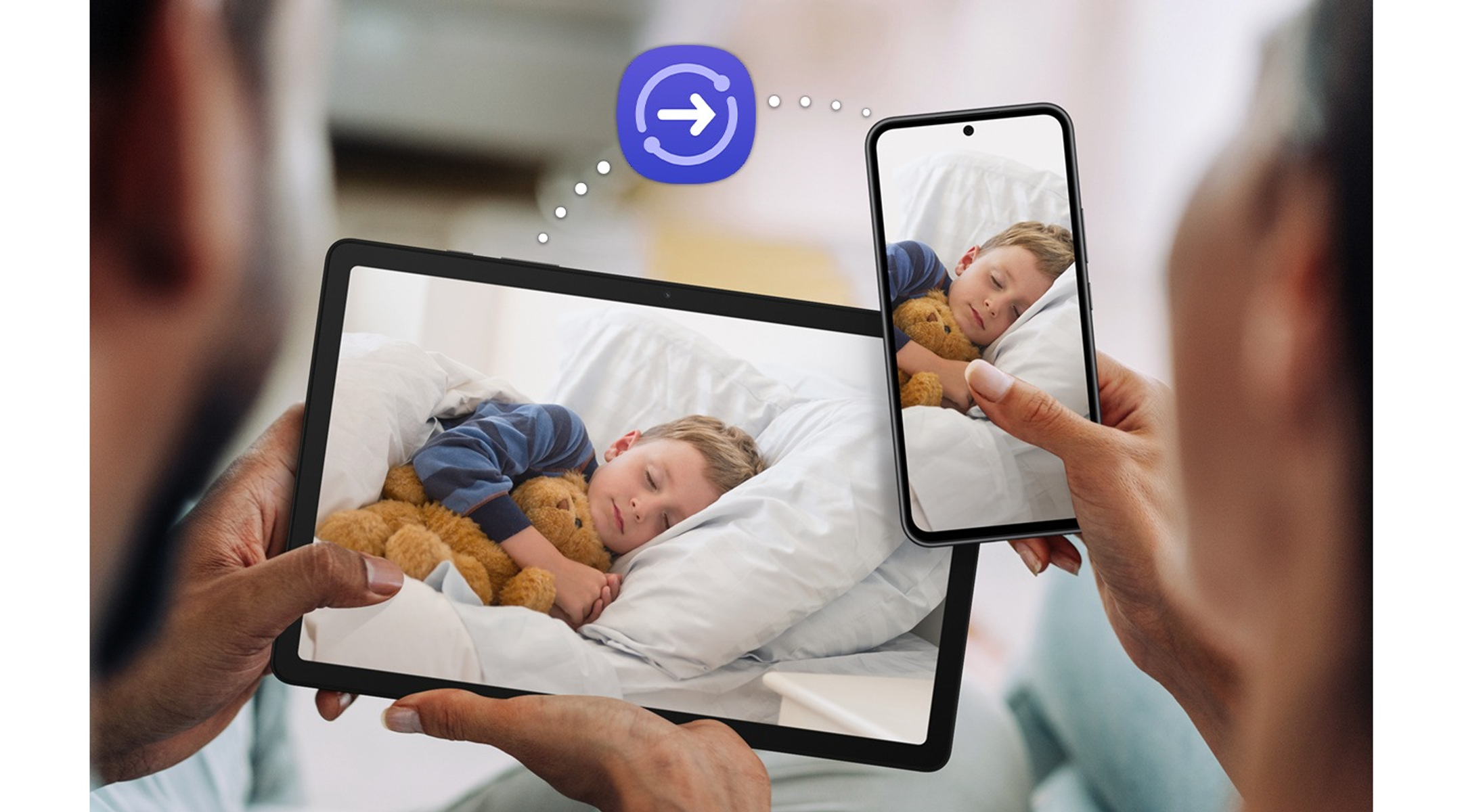 Tablet i smartfon pokazujące ten sam obraz śpiącego dziecka, z ikoną przesyłania.