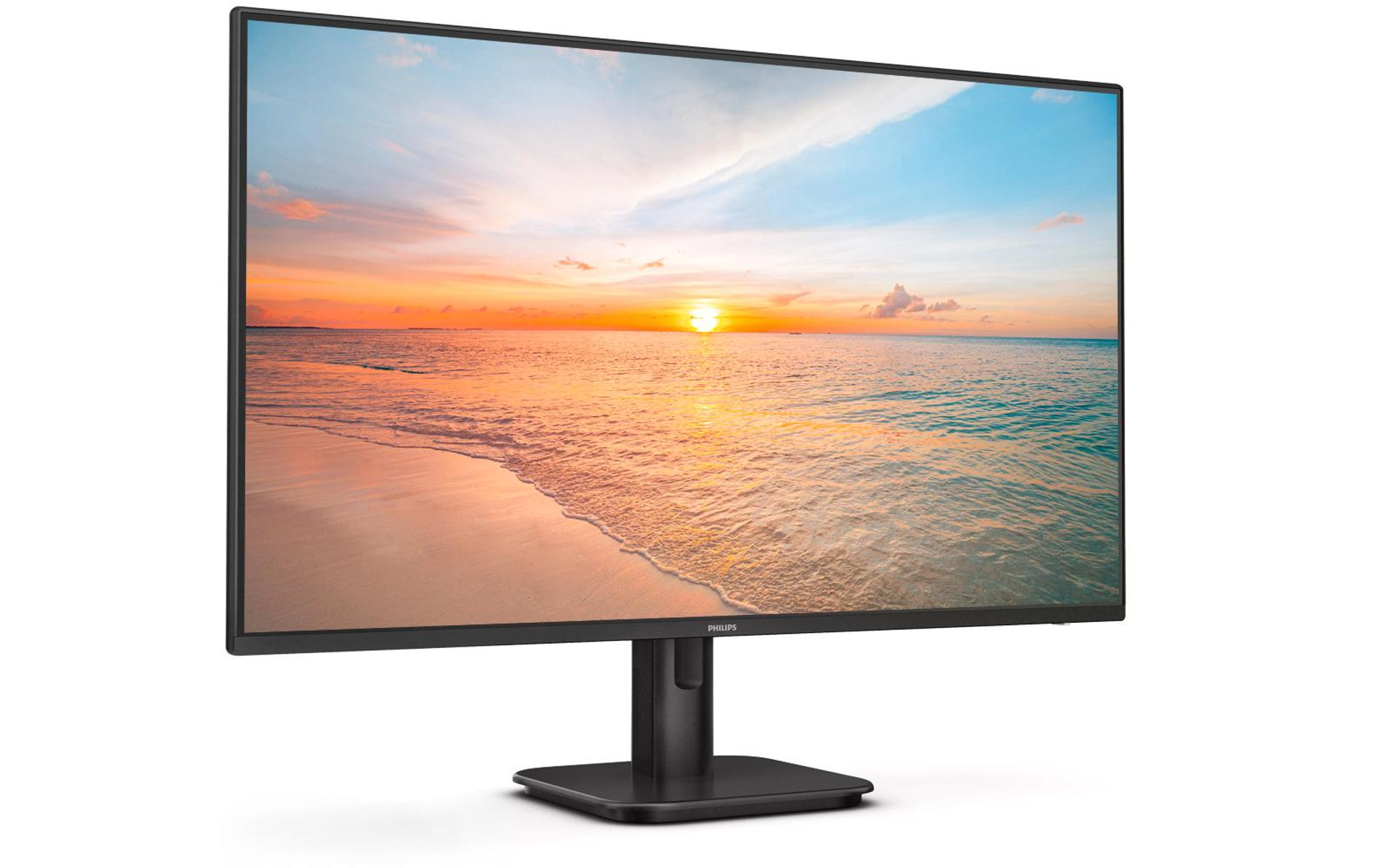 Monitor wyświetla scenę plażową ze wschodem słońca, zamontowaną na czarnym stojaku, na białym tle.