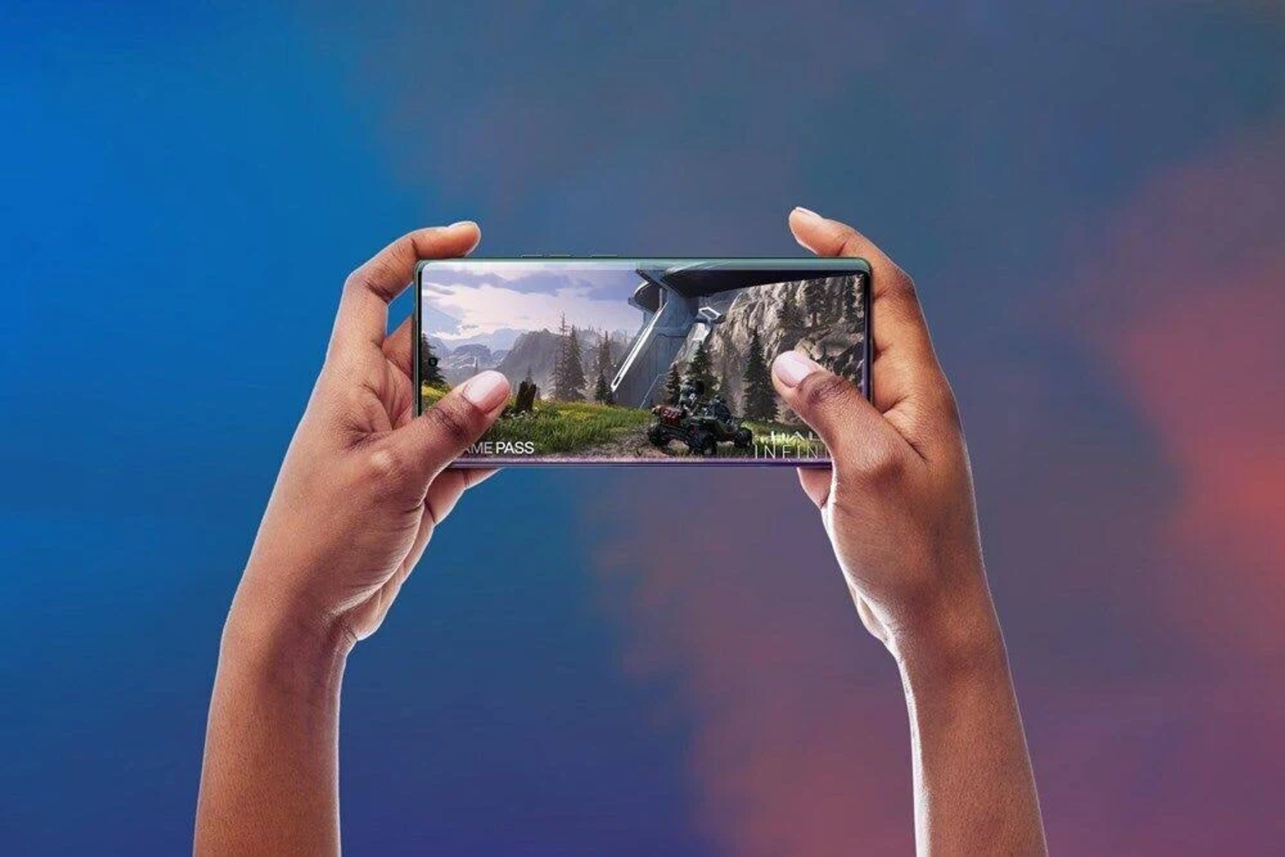 Ręce trzymające telefon grający w grę wideo z górami.