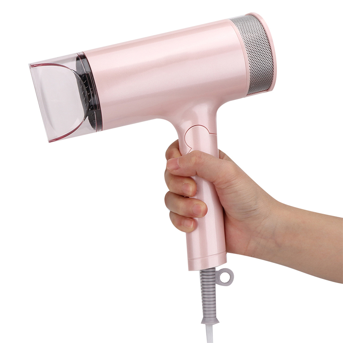 Eine Person hält einen rosa Haartrockner. Der Griff wird gehalten. Der Kopf des Haartrockners zeigt nach links.