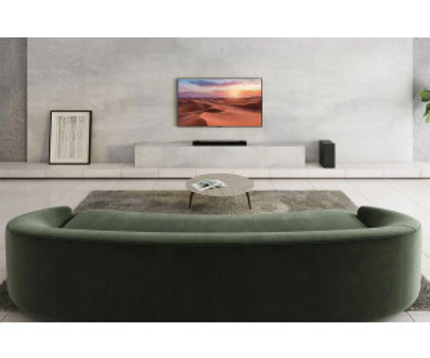Ein Wohnzimmer mit einem grünen, geschwungenen Sofa, einem Fernseher und einer Soundbar auf einem weißen Schrank.