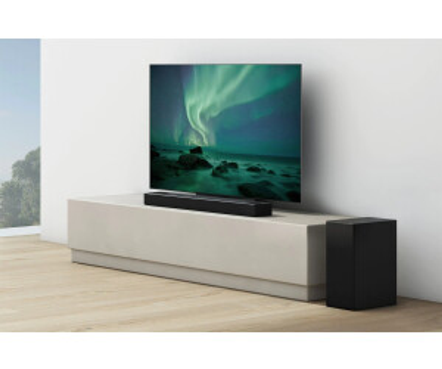 Wohnzimmer mit großem Fernsehbildschirm, der Nordlichter zeigt. Eine Soundbar steht auf dem Ständer unter dem Fernseher. Schwarzer Subwoofer.