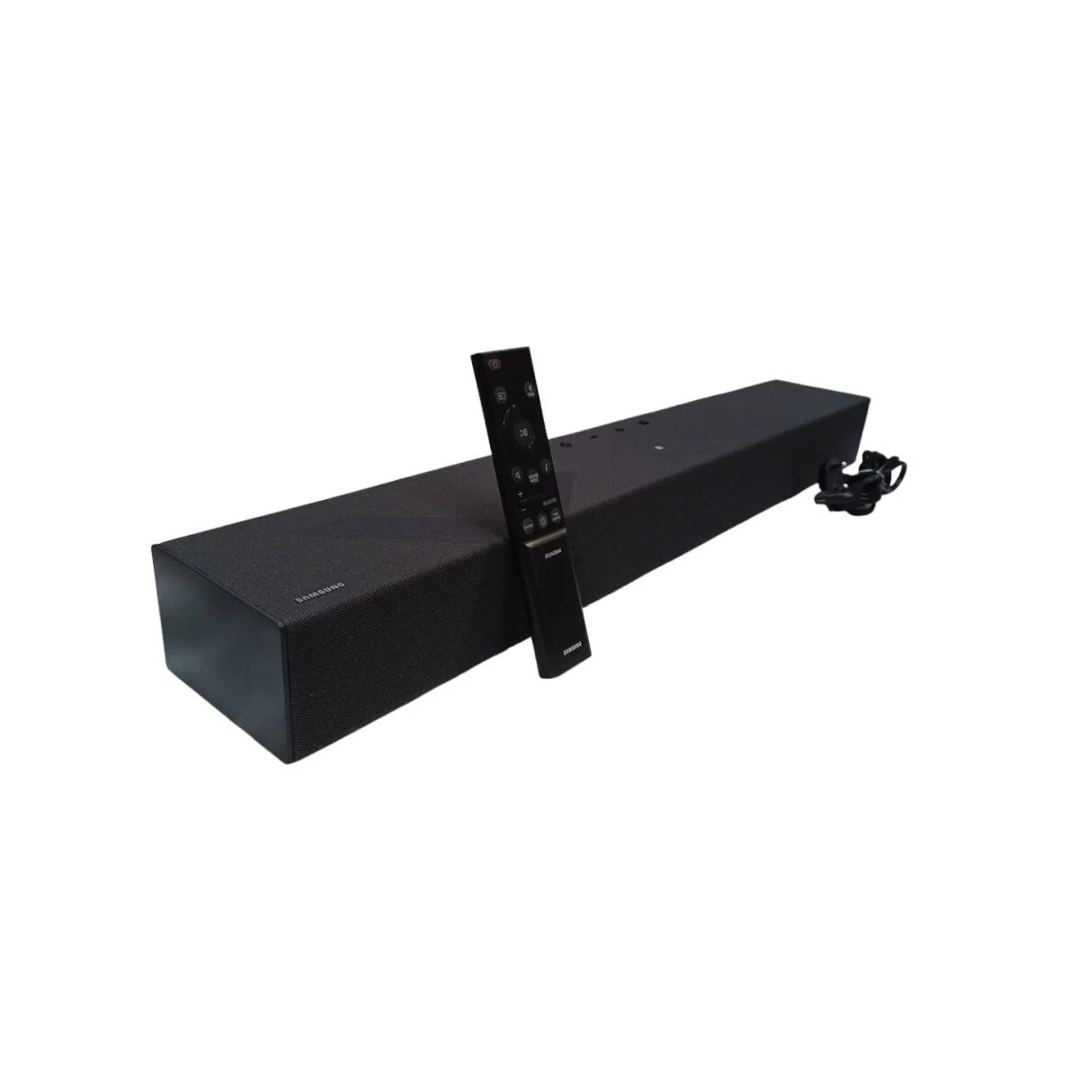 Czarny soundbar z pilotem na białym tle.