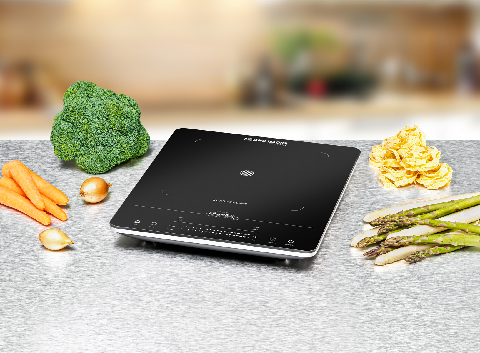 Płyta indukcyjna z warzywami. Brokuły, marchew, cebula, szparagi i chipsy na powierzchni.