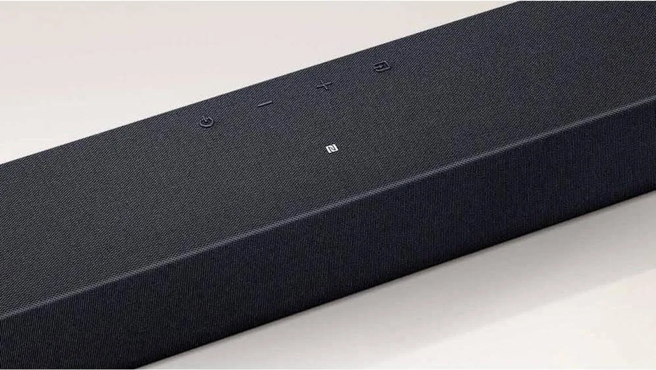 Zbliżenie czarnego soundbaru z przyciskami i fakturą materiału.