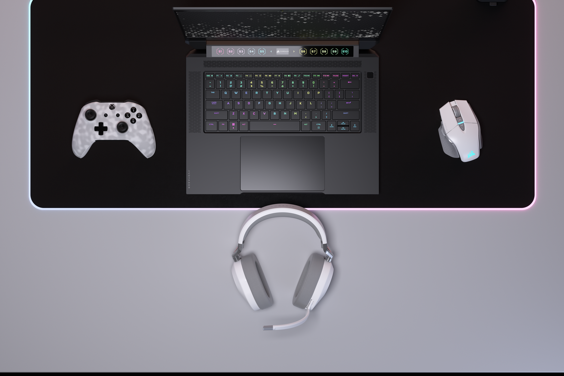 Laptop, kontroler, mysz i słuchawki na biurku, widok z góry.