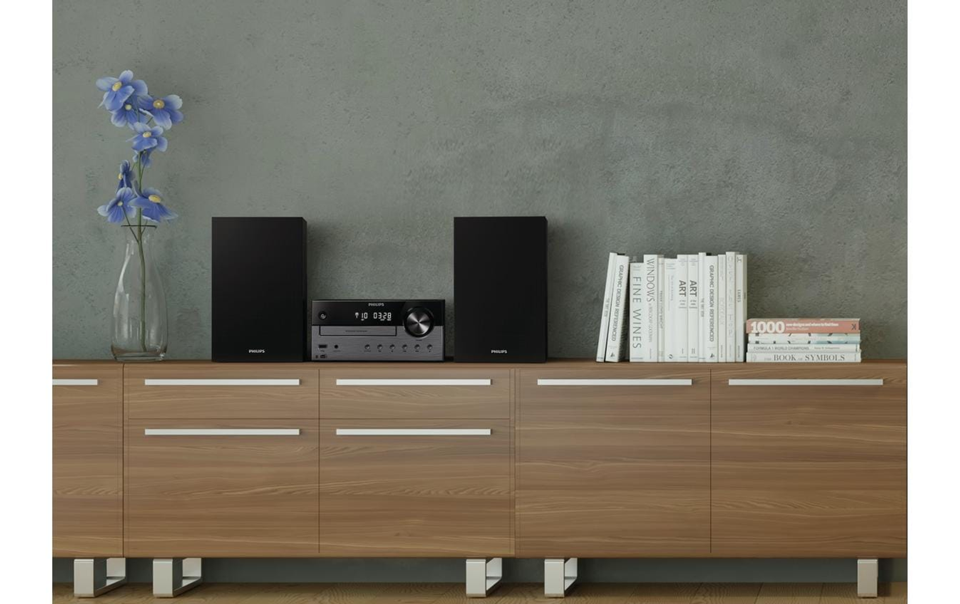 Zestaw stereo z dwoma czarnymi głośnikami, jednostką centralną i stos książek na drewnianej szafce.