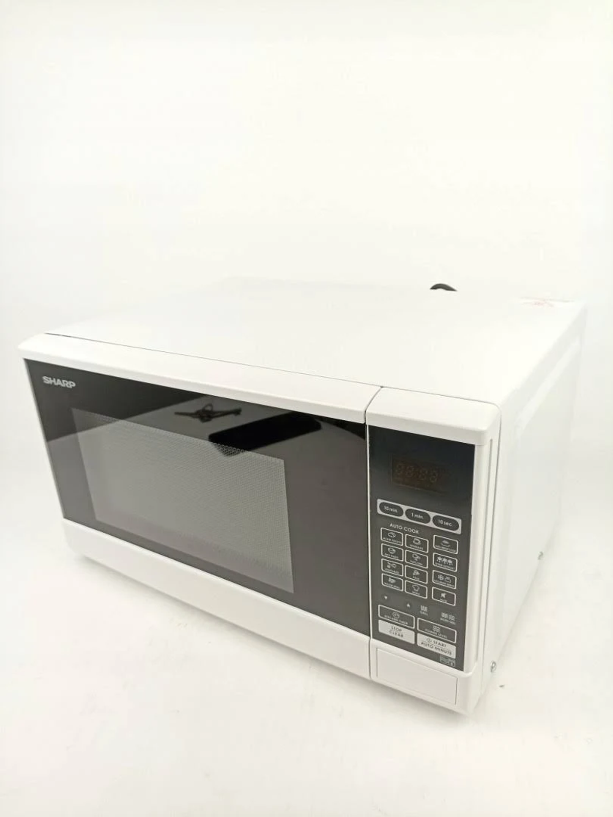 Un horno microondas SHARP blanco sobre un fondo blanco. Tiene una puerta y un panel de control negros.