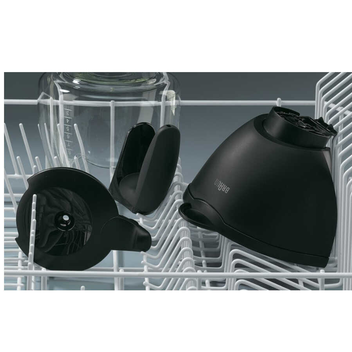 Części ekspresu do kawy, w zmywarce, w tym szklana karafka i czarne elementy.