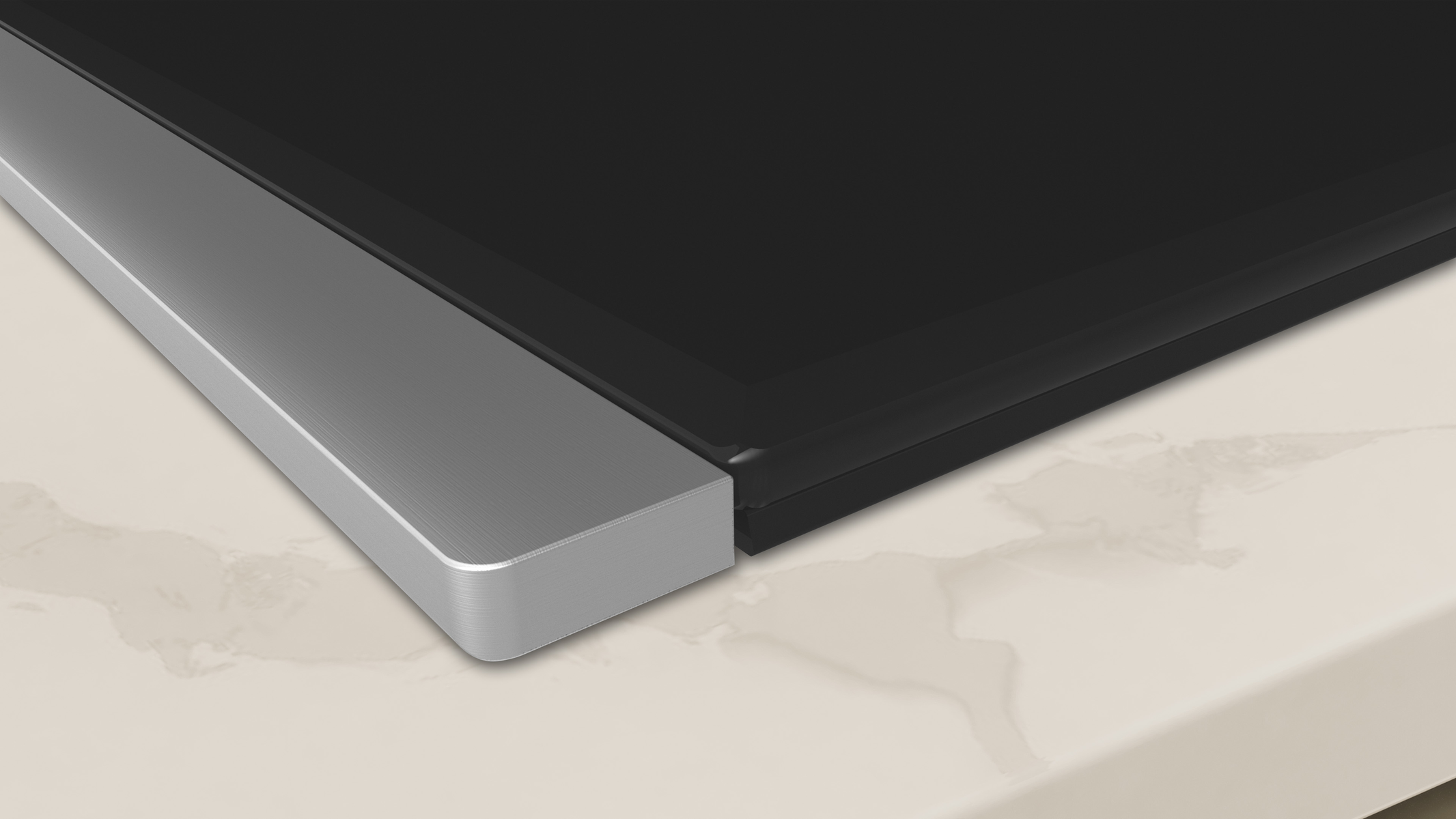 Zbliżenie czarnej płyty grzewczej ze szklanym blatem i srebrną ramą, na jasnej powierzchni.