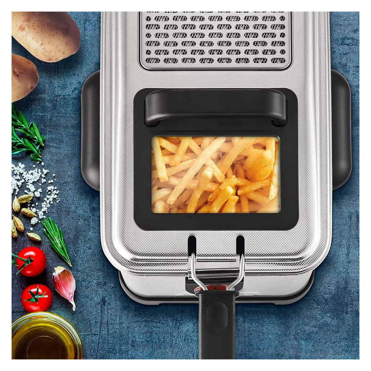 Frytownica ze stali nierdzewnej z frytkami w oknie, składniki i ziemniaki na pierwszym planie.