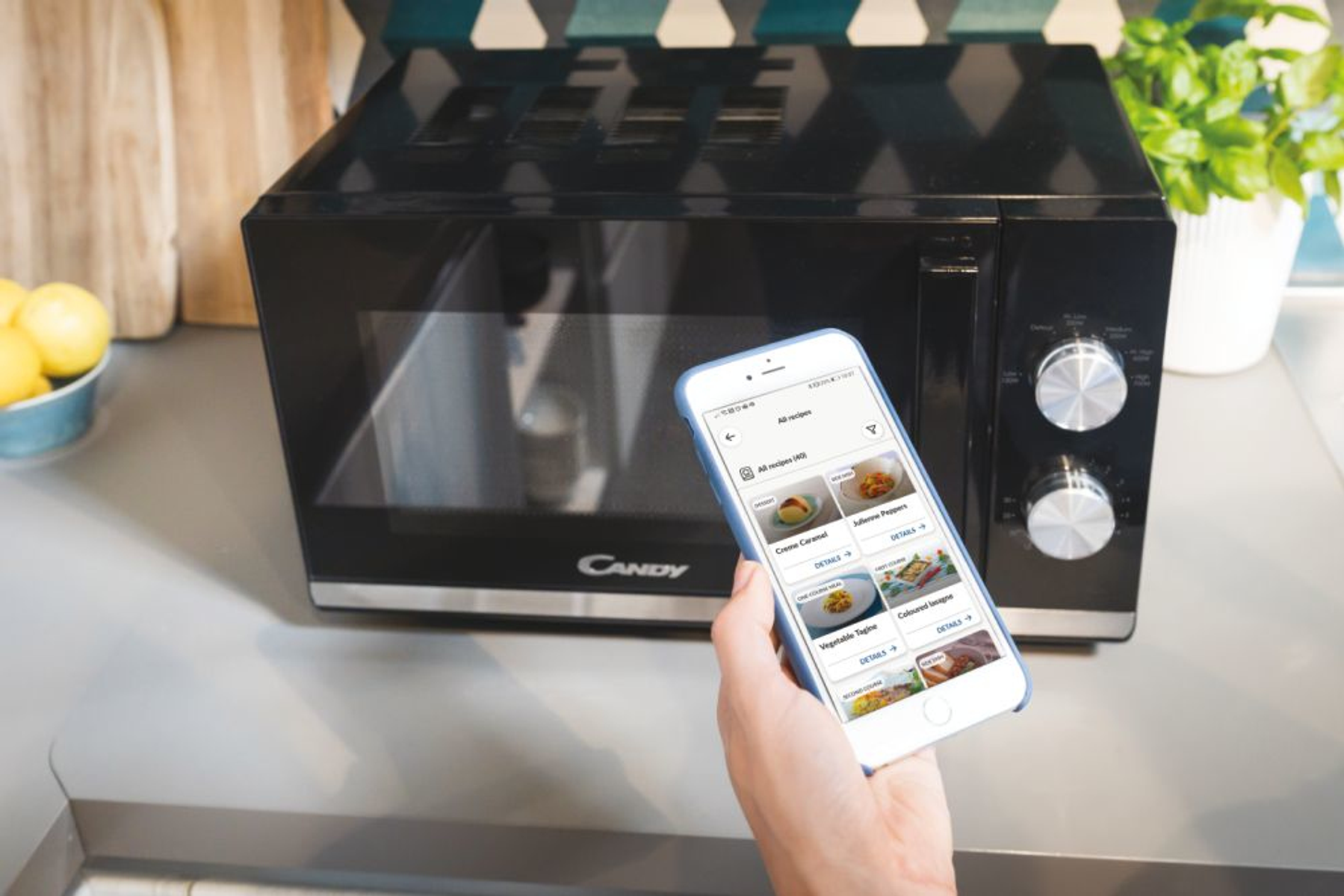Kuchenka mikrofalowa z telefonem pokazującym aplikację z przepisami.