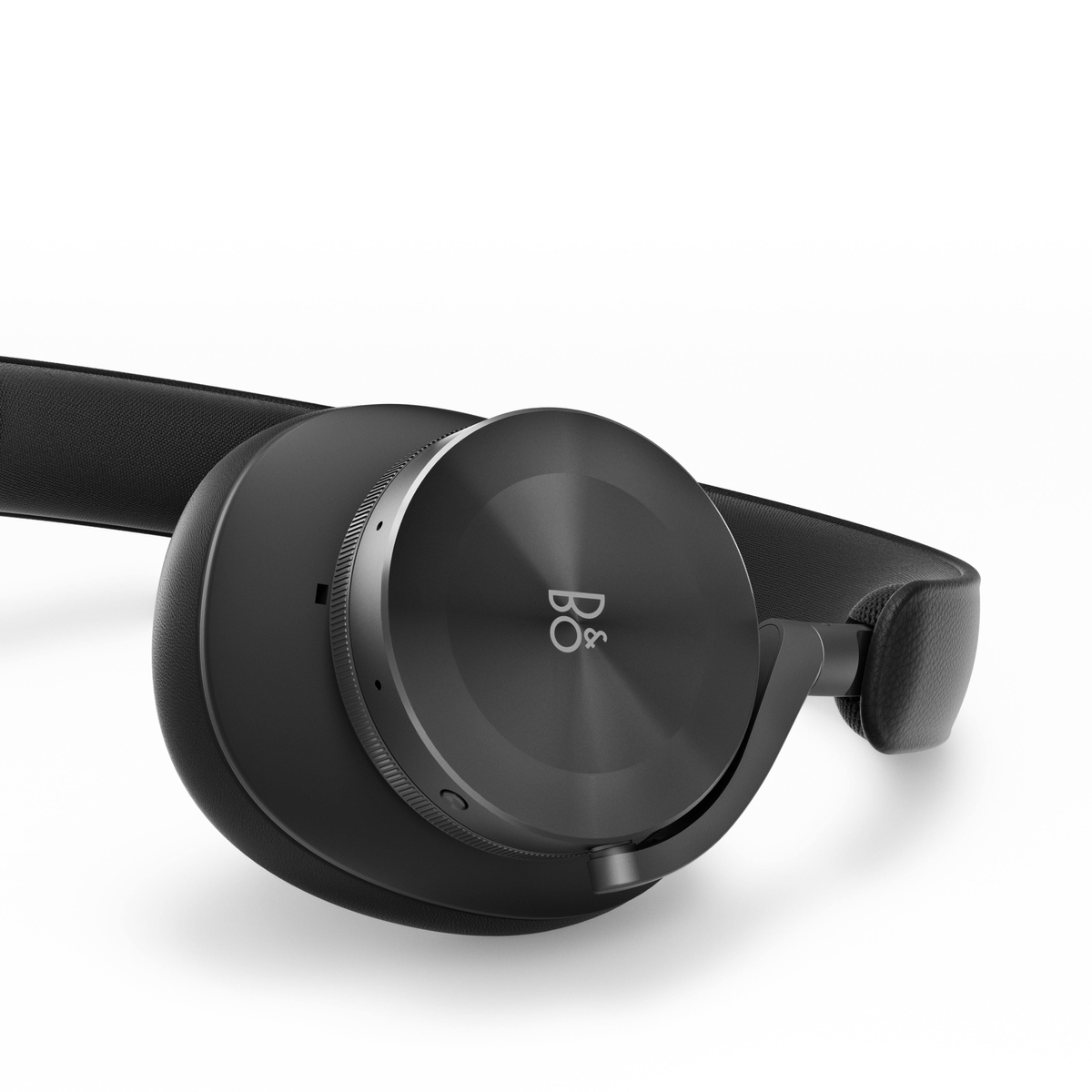 Schwarze Kopfhörer, kreisförmiges Ohrmuscheldesign, ruhend auf weißer Oberfläche.