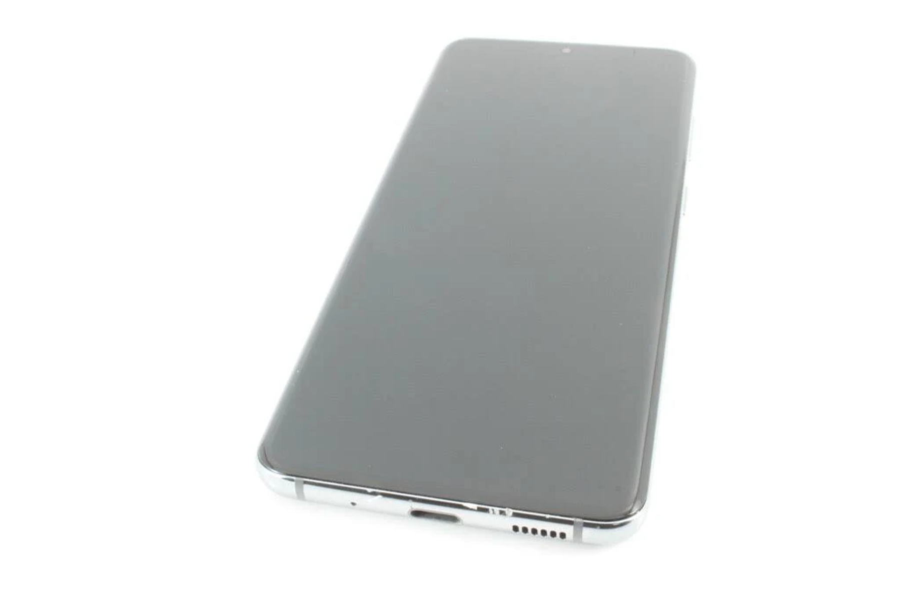 Uno smartphone su una superficie bianca. Lo schermo è nero e il telaio è argento.