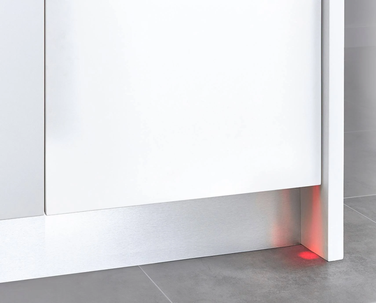 Primer plano de un armario blanco con una luz roja brillando en la parte inferior.