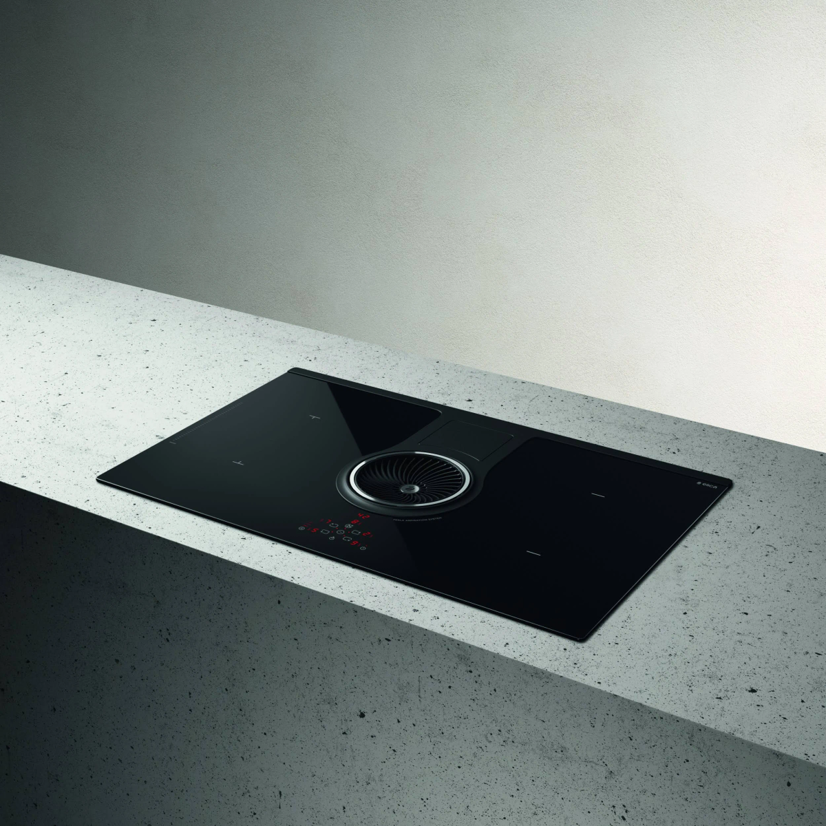 Czarna płyta grzejna ze zintegrowaną wentylacją. Leży na jasnoszarym blacie.