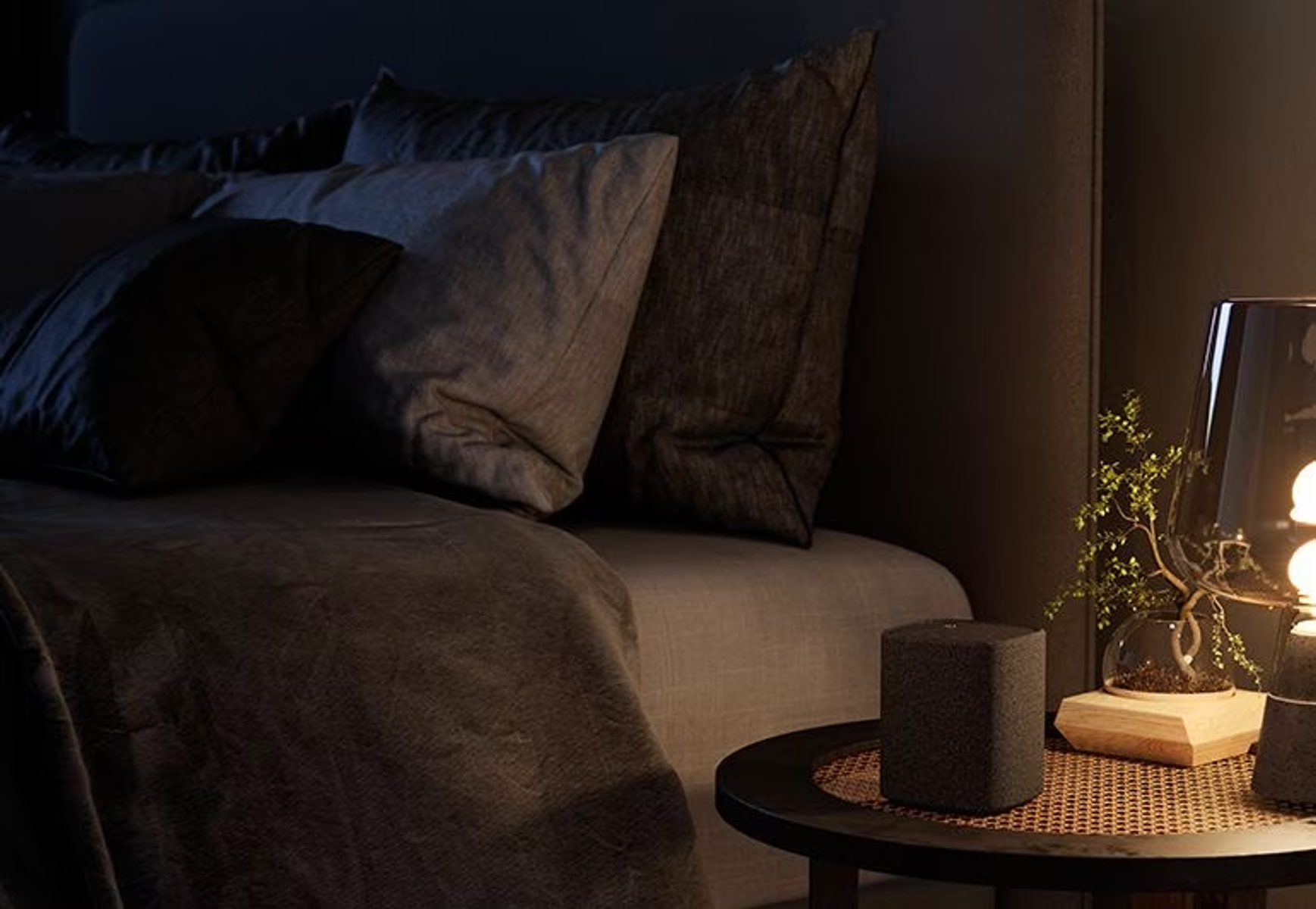 Scena sypialni nocą z głośnikiem na stoliku nocnym.