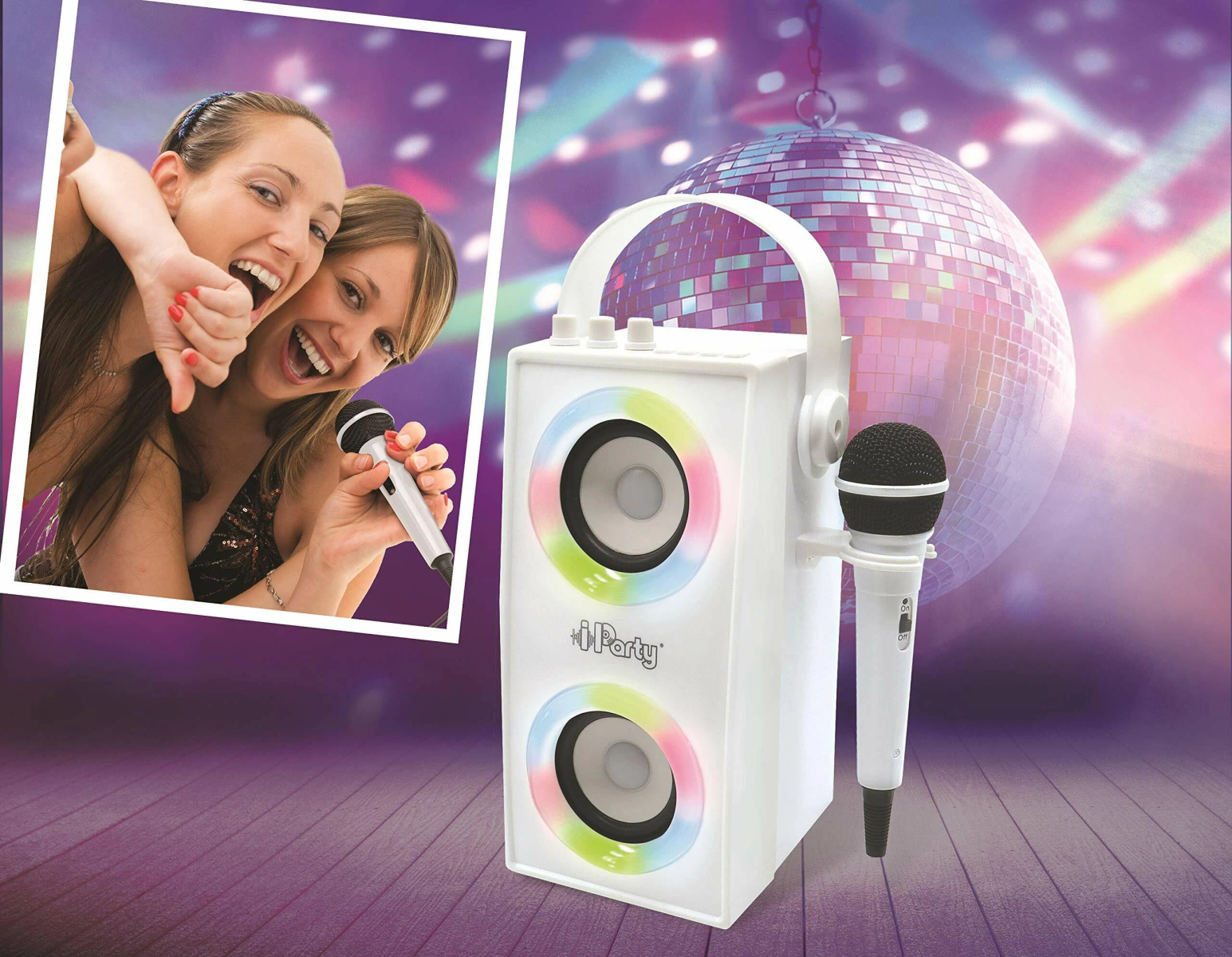 Due donne che cantano felicemente con dei microfoni davanti a un altoparlante bianco. Una palla da discoteca sullo sfondo.
