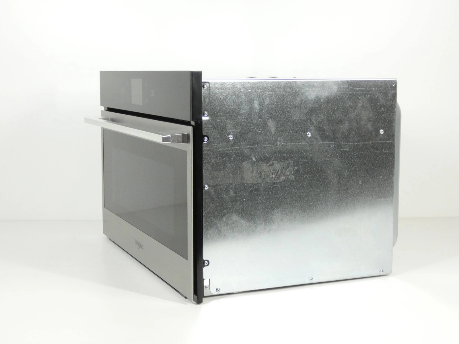 Zijaanzicht van een roestvrijstalen magnetron met donkere glazen deur en handvat.