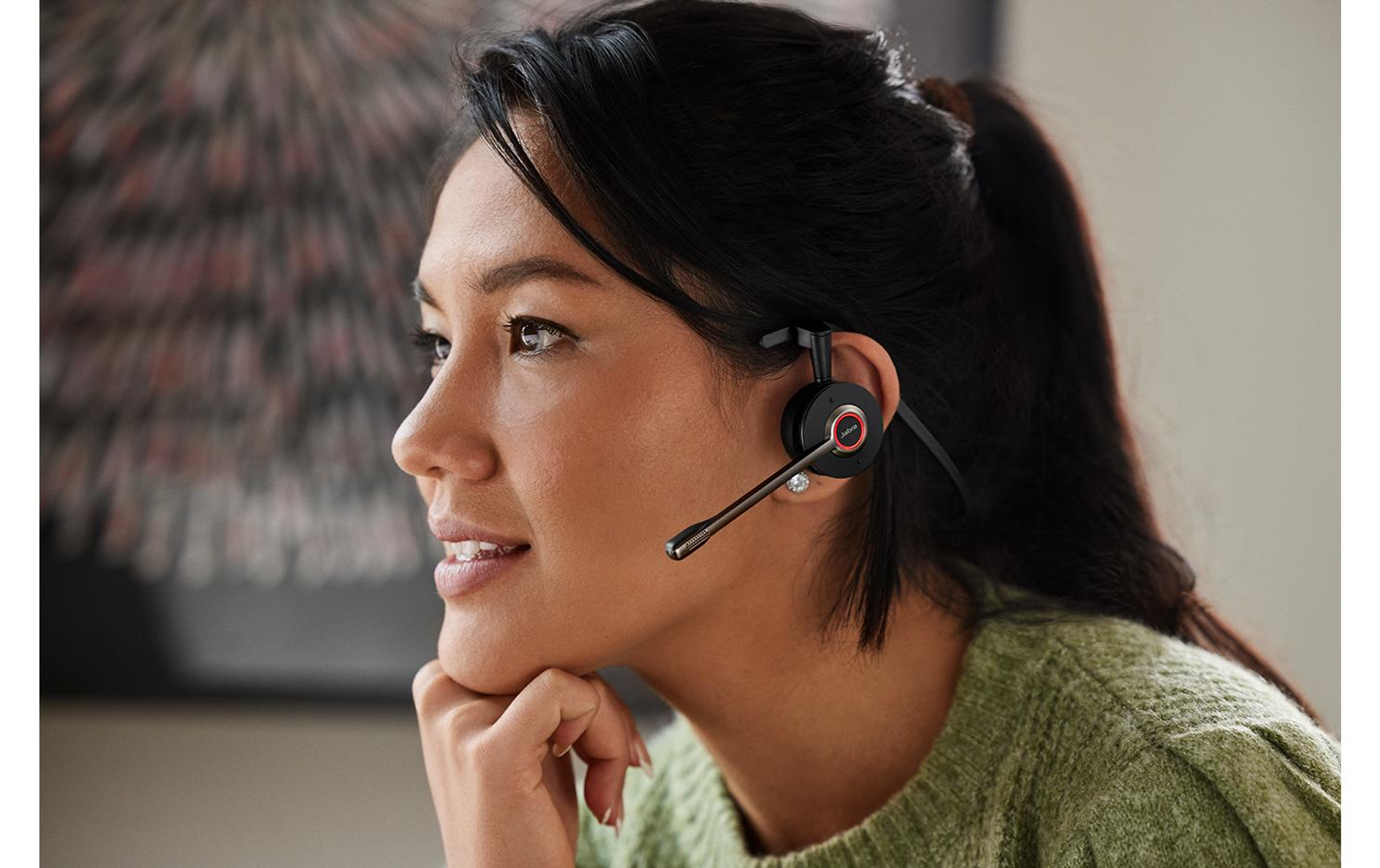 Kobieta w słuchawkach, odwrócona. Tło lekko rozmyte.