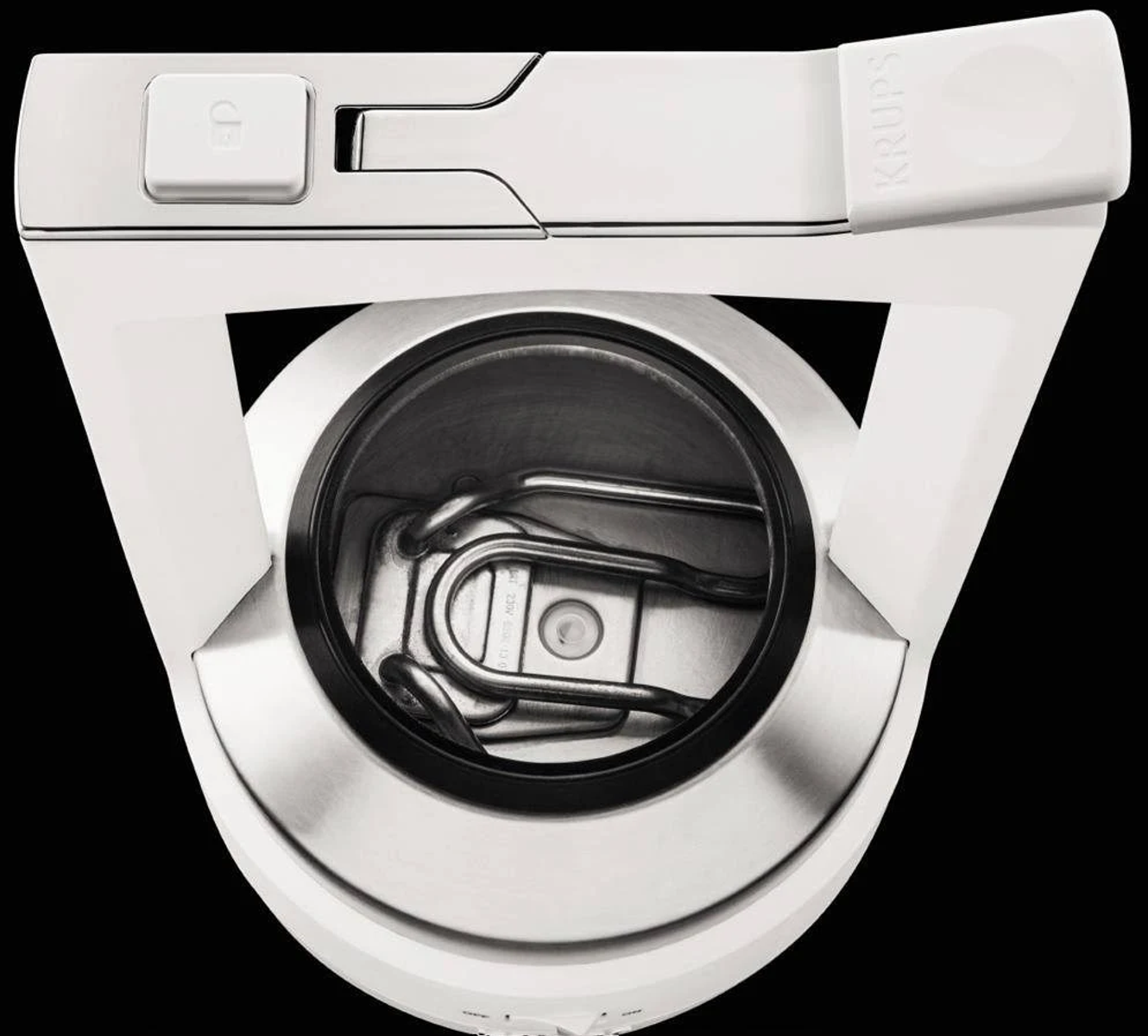 Widok wewnętrzny białego ekspresu do kawy Krups z widocznymi elementami grzewczymi.